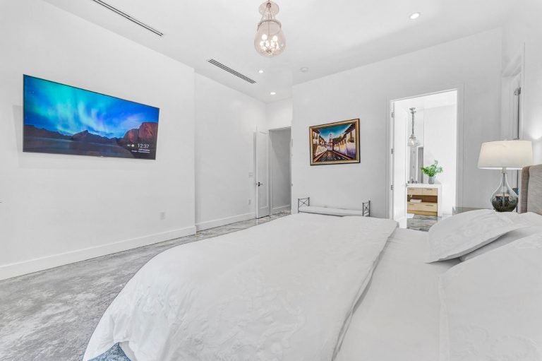 Bright bedroom with wall-mounted television and garden-facing window