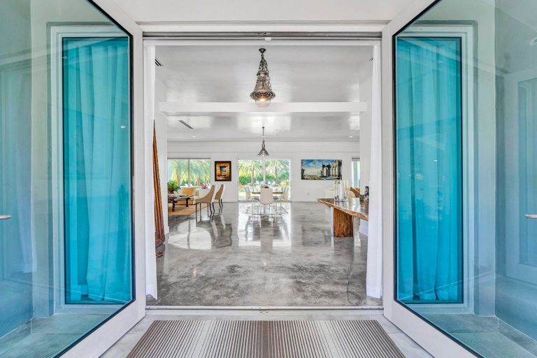 Blue glass entry doors opening into the Miami estate