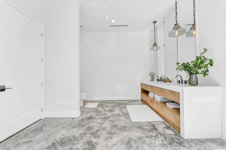 Minimal entry console with pendant lights and polished stone floor