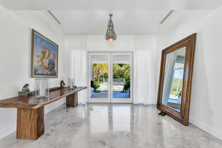 Entrance foyer with a wood console, oversized mirror, and garden doors