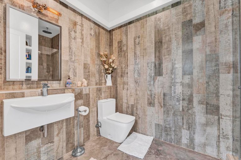Bathroom with warm wood-look tile and a glass shower enclosure